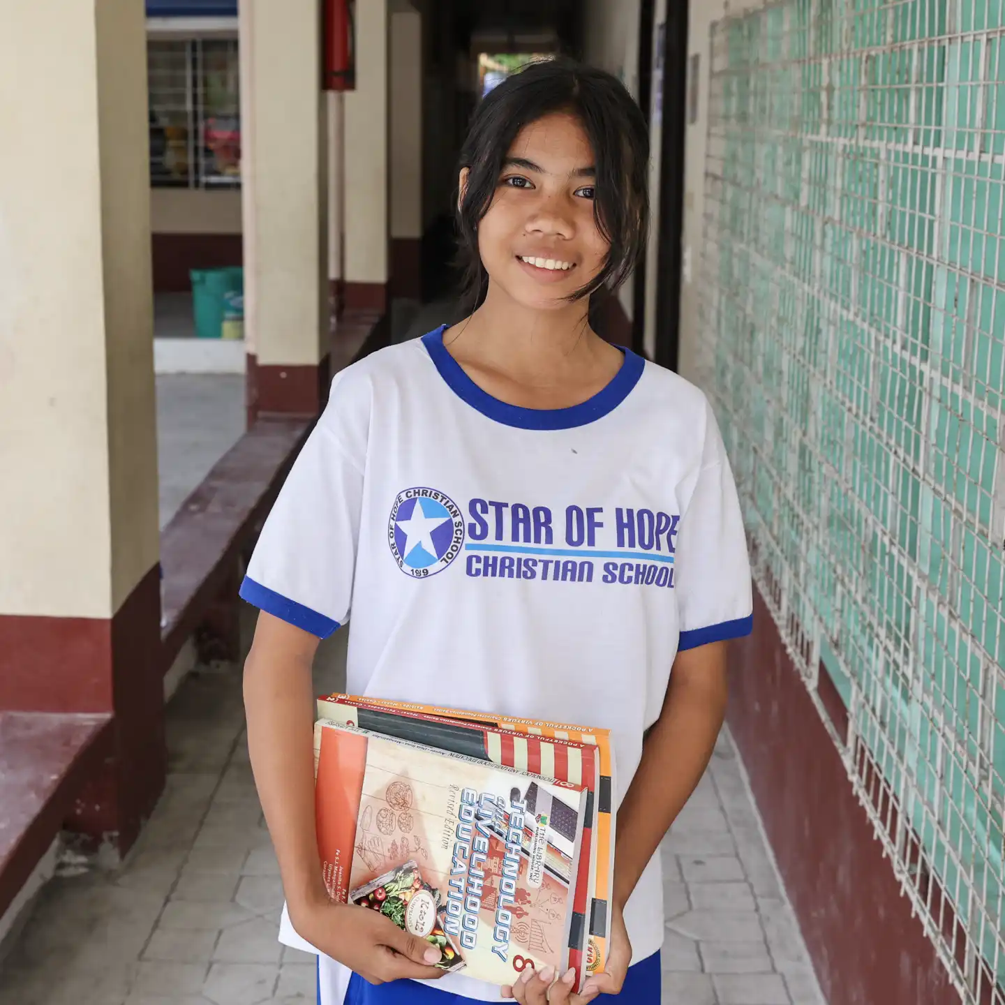 Flicka med skolböcker i Filippinerna.