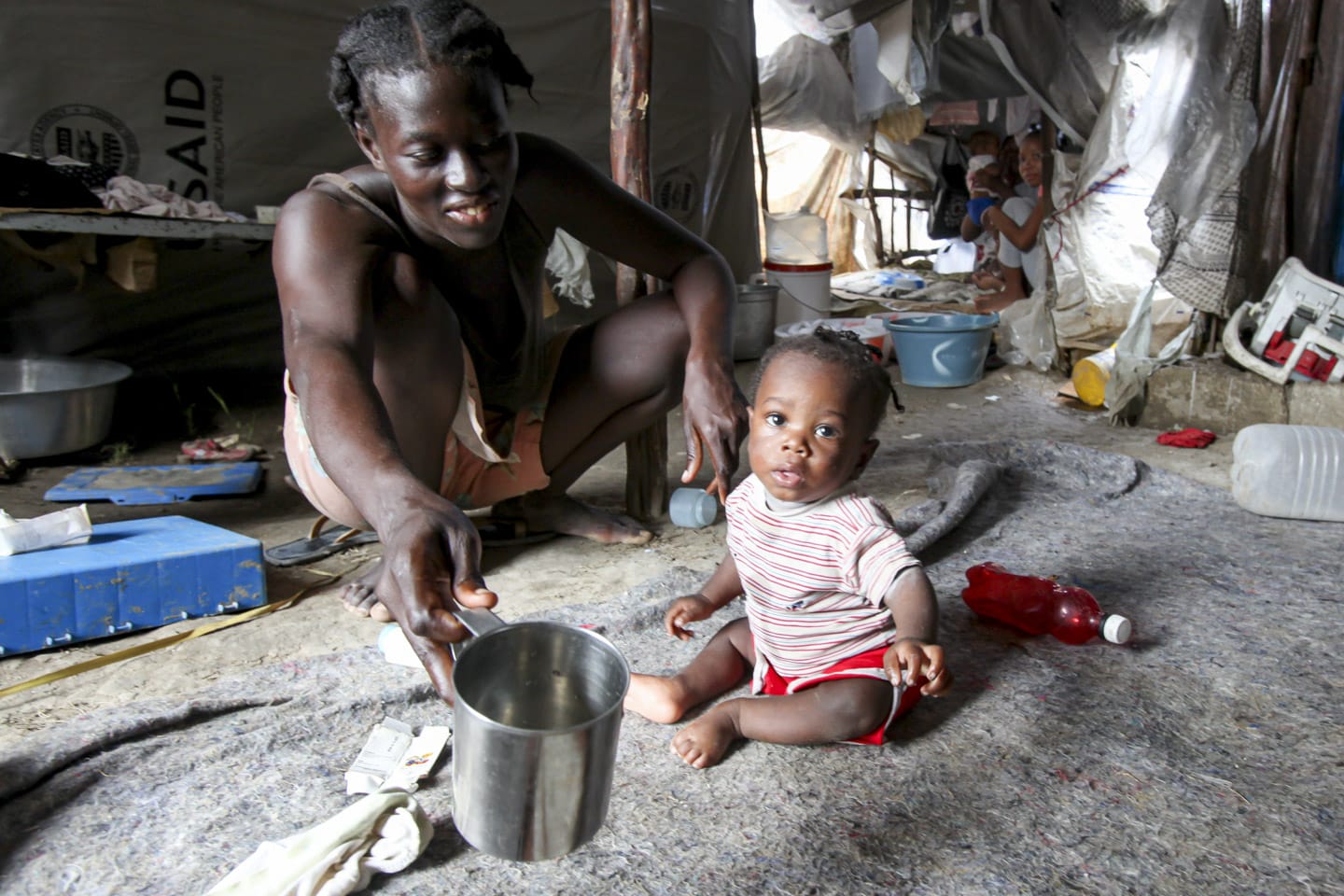 kvinna matar barn haiti