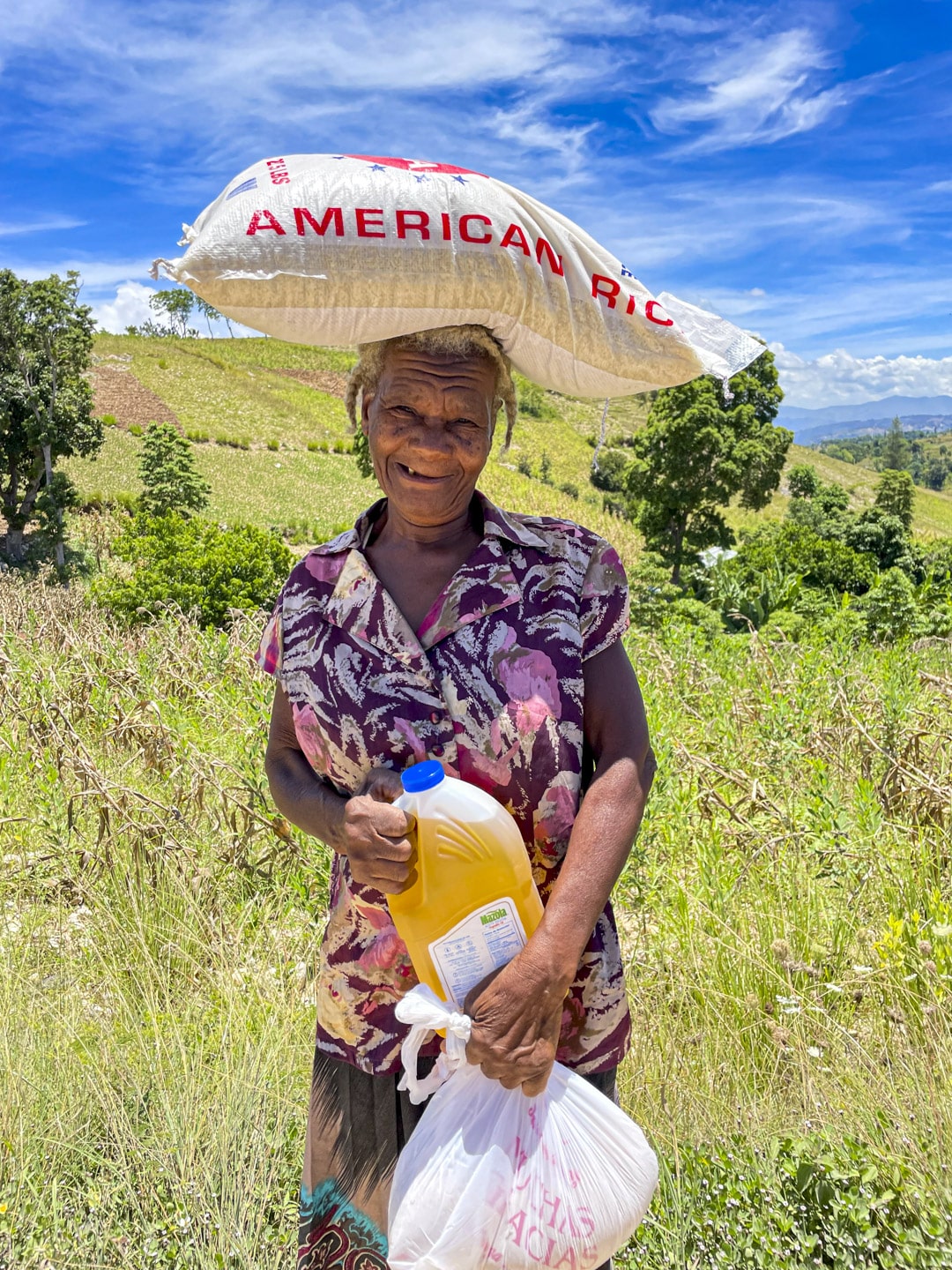 Glad kvinna med matpaket i Hesse, Haiti