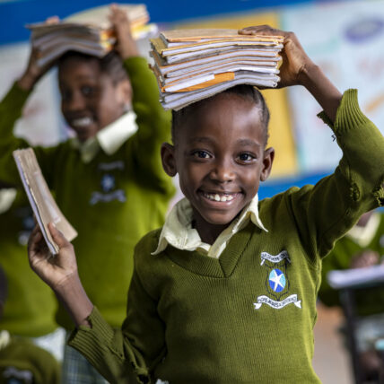 Flicka med skolböcker i Kenya.