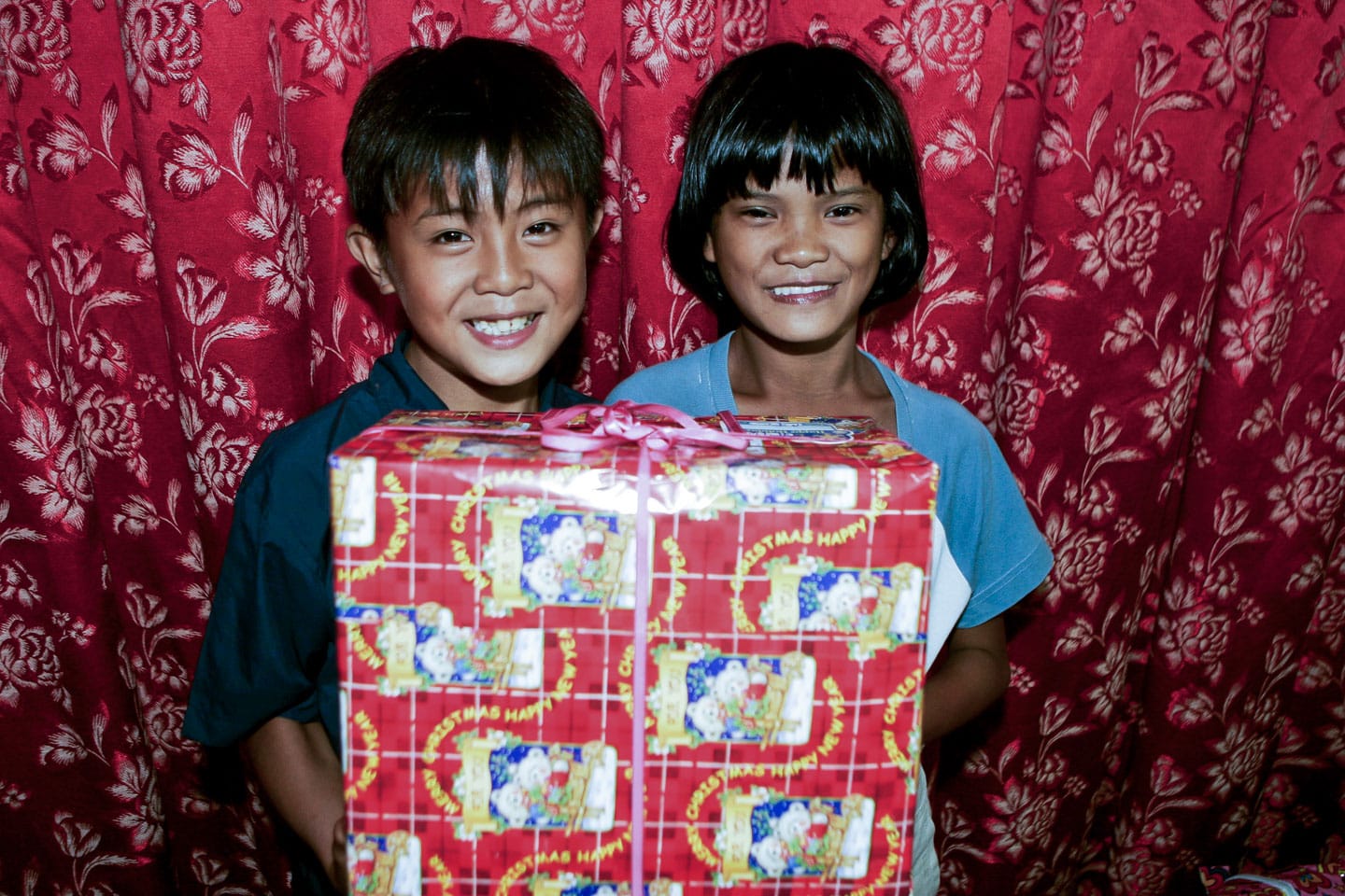 Två barn med julpaket i Filippinerna