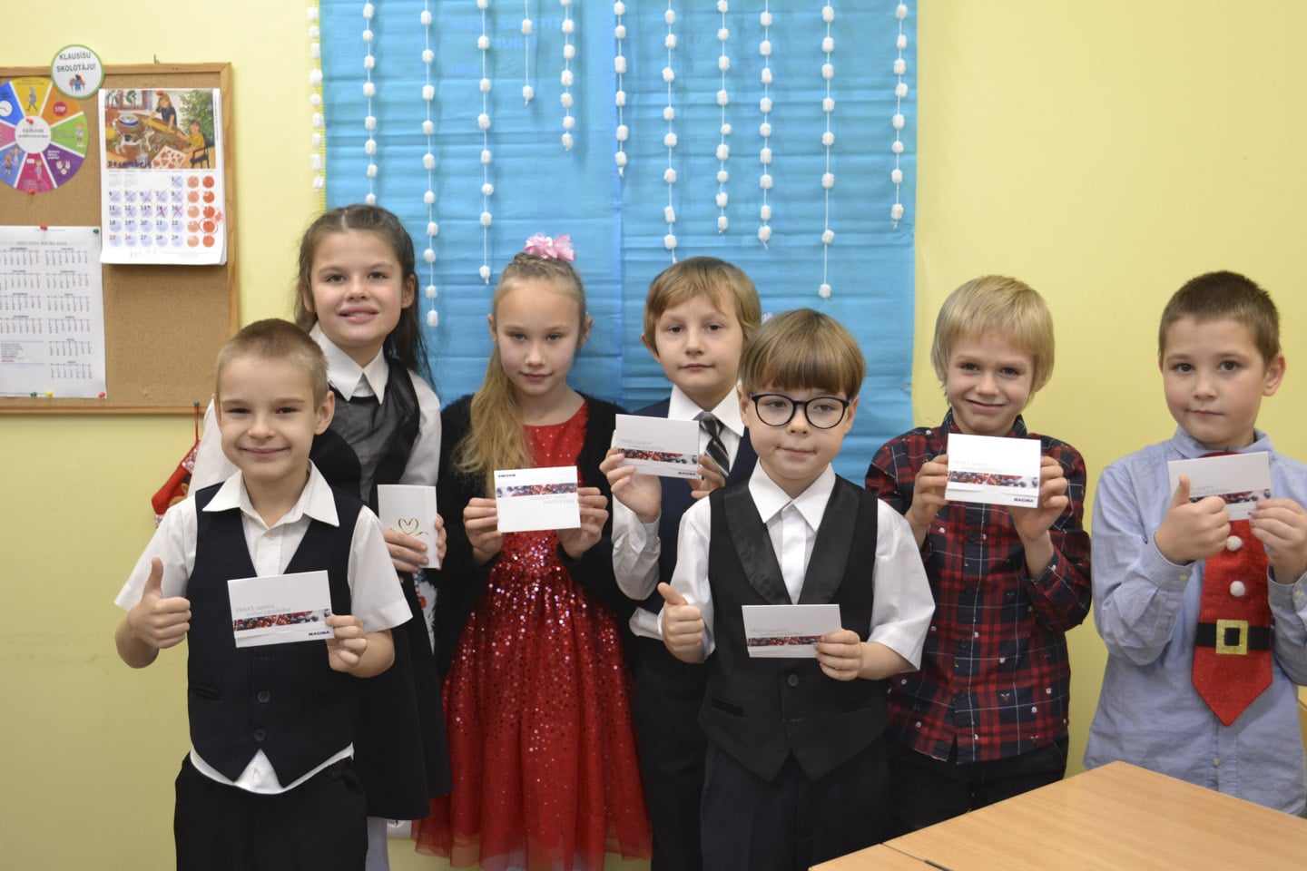 Glada barn i Lettland som tagit emot ett presentkort inför jul så de kan köpa mat till familjen.