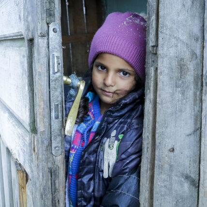 Flicka i dörröppning i Rumänien