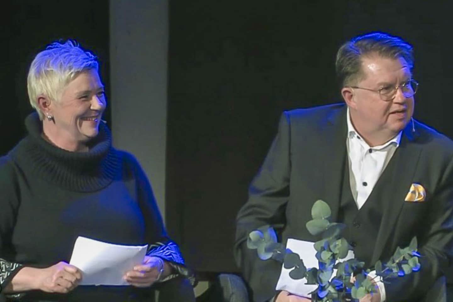 man och kvinna på scen i kyrka.
