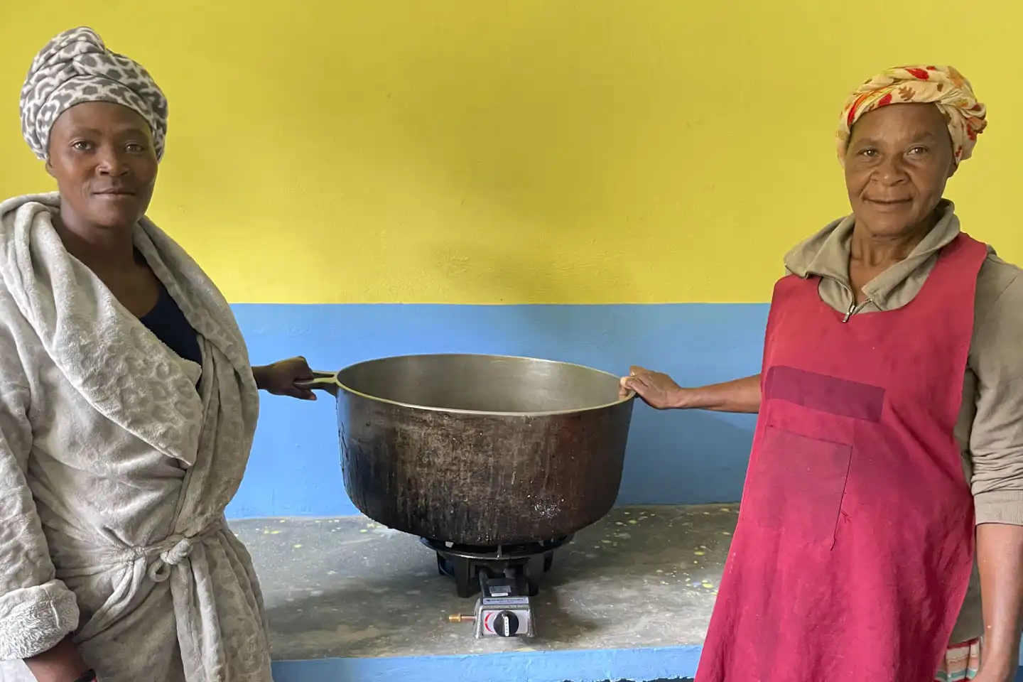 Två kvinnor med gryta i Haiti