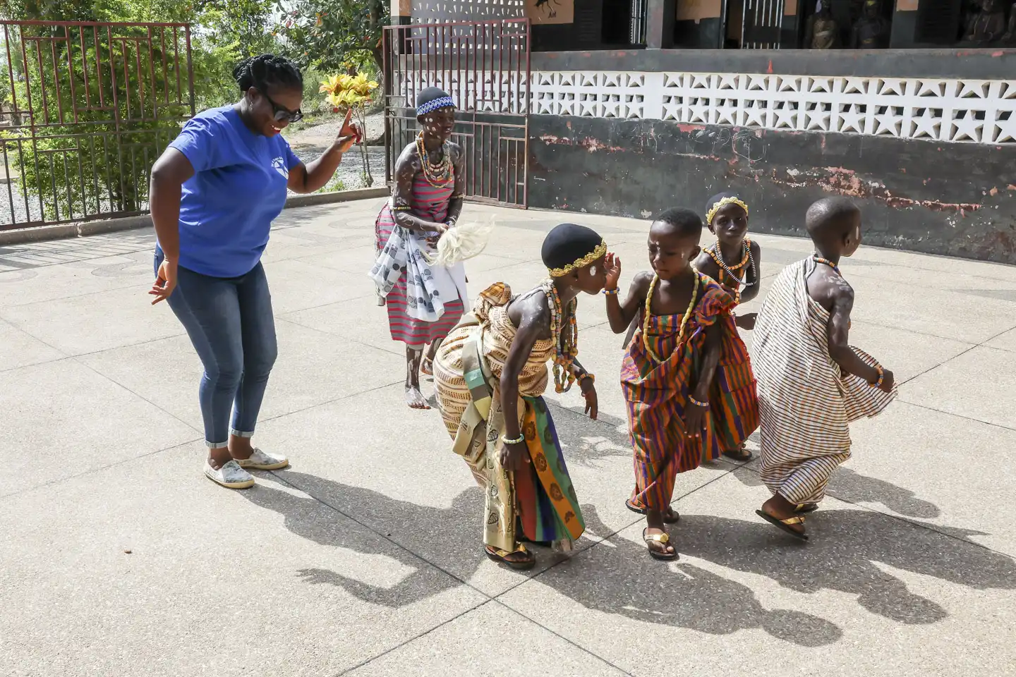 Kvinna dansar kulturdans med barn i Ghana
