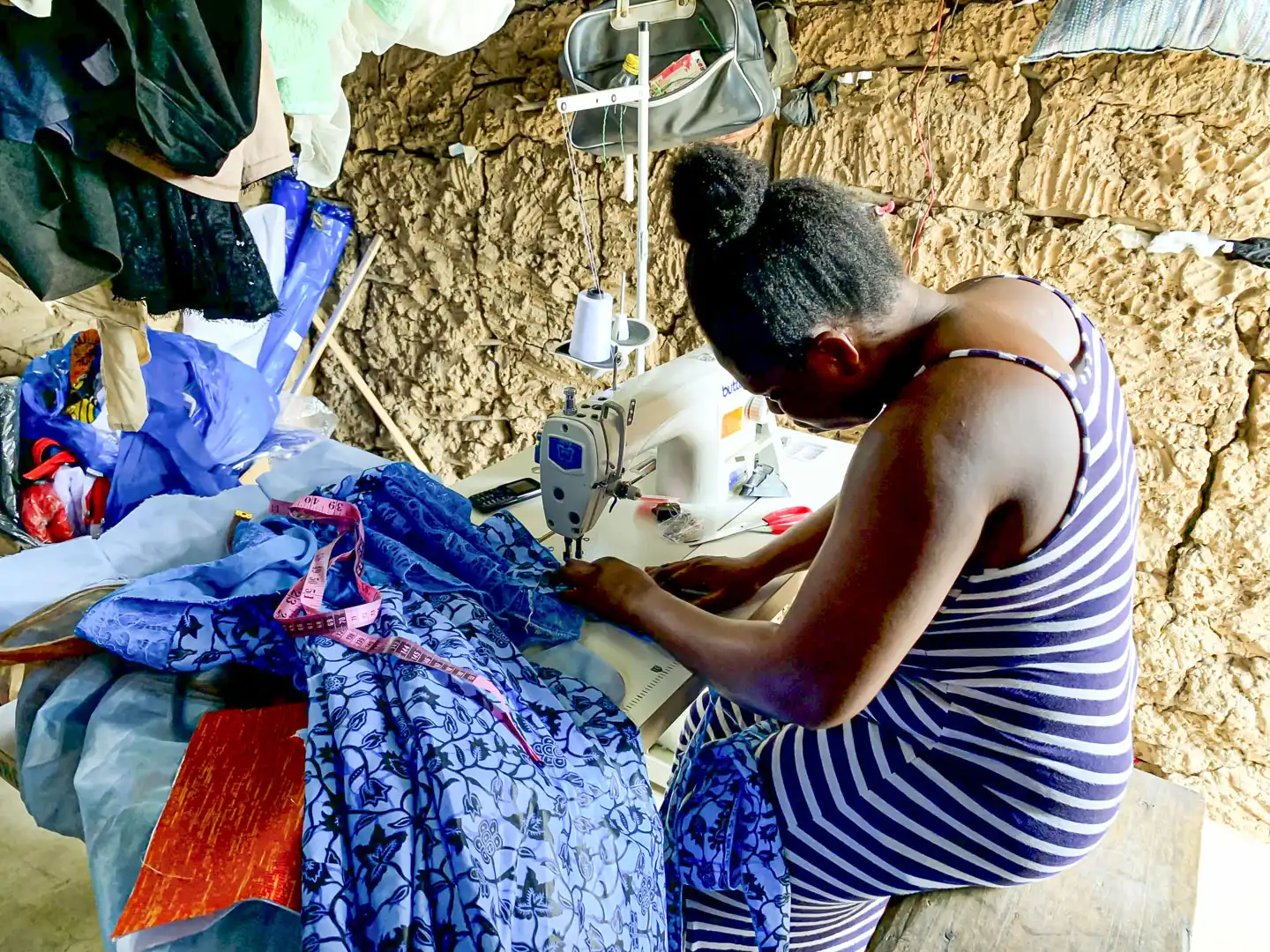 Kvinna syr kläder med symaskin i Ghana.