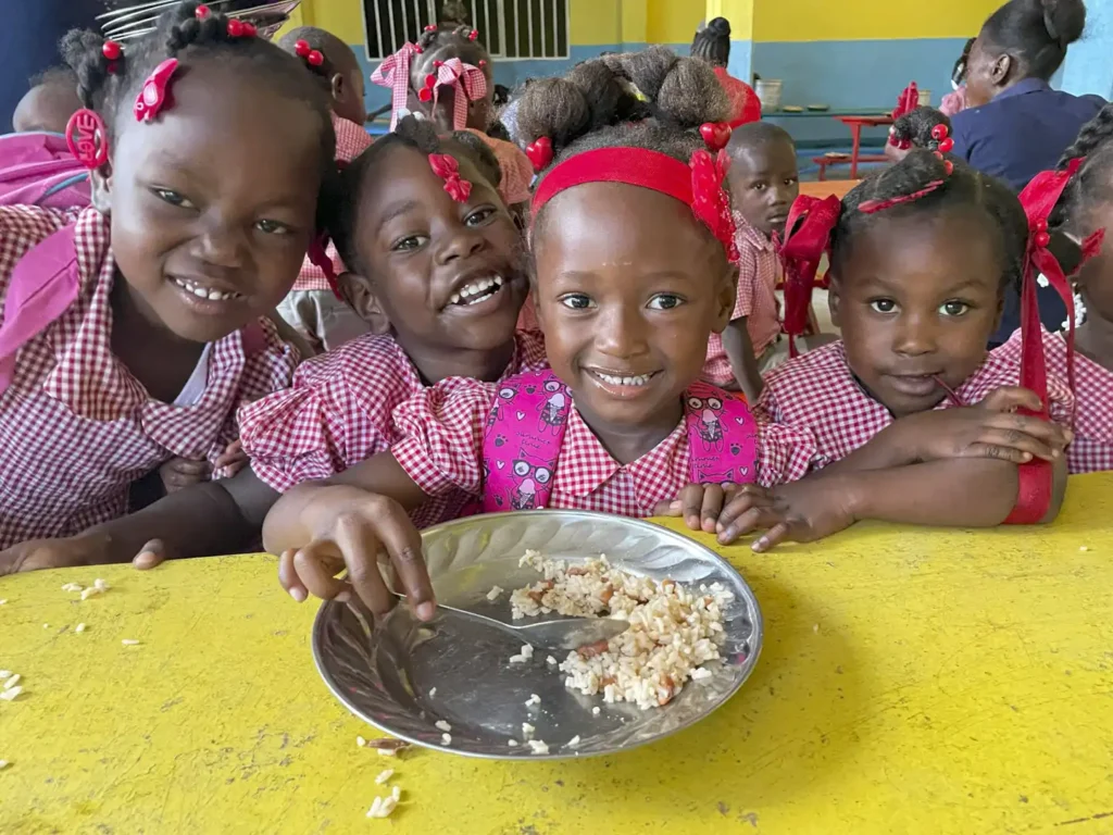 Barn äter lunch i skolan i Haiti.