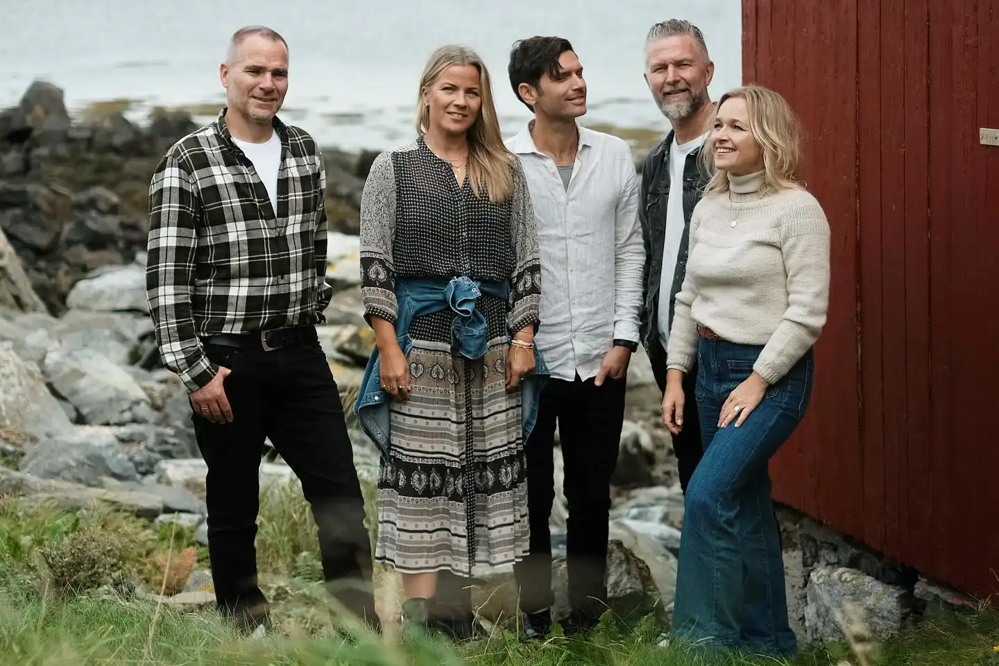 fem personer står vid ett hus i norge