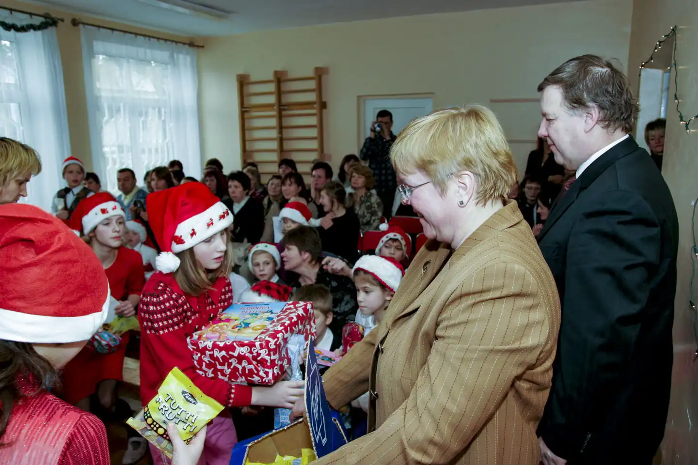 man och kvinna delar ut julklappar på dagcenter