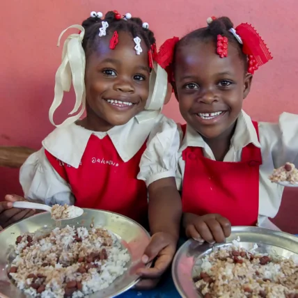 två barn äter lunch i Haiti