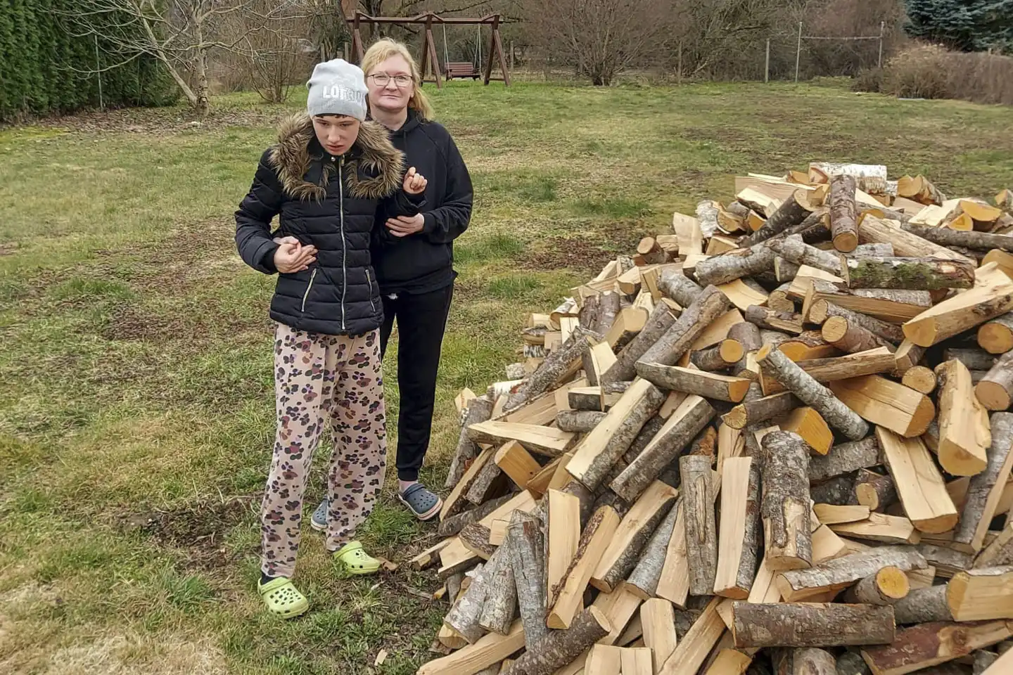 Barn och mamma med ved i Lettland.