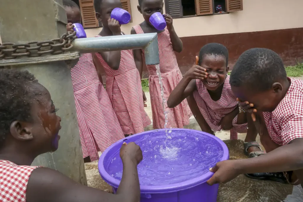 barn vid vattenbrunn i Ghana