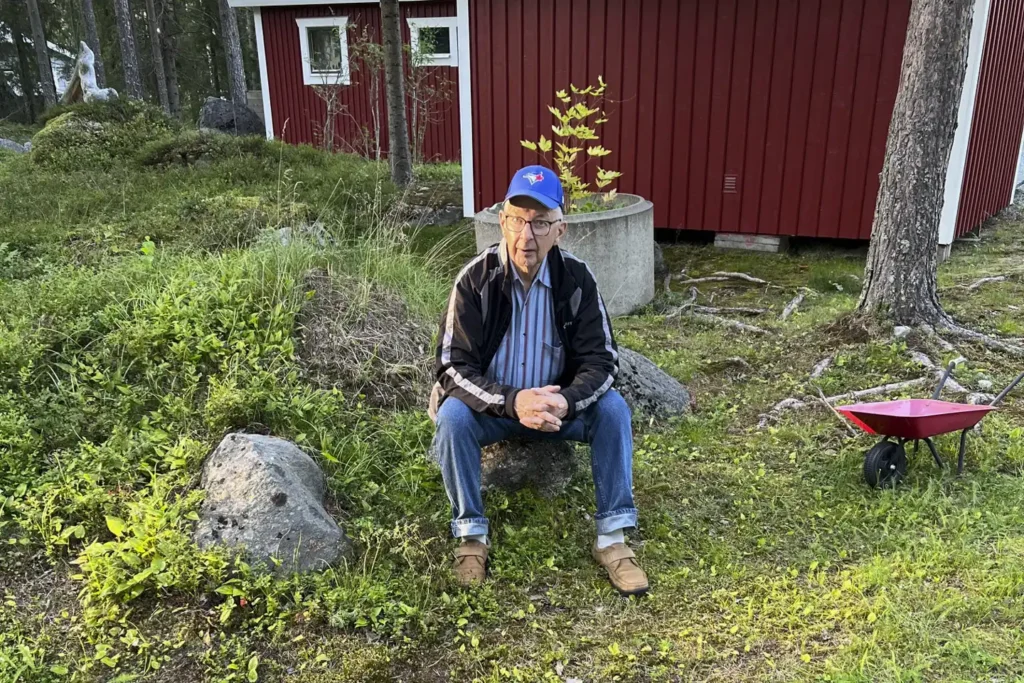 Man sitter på sten på landet