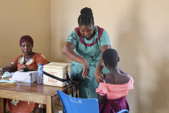 kvinna vaccinerar ett barn i Ghana