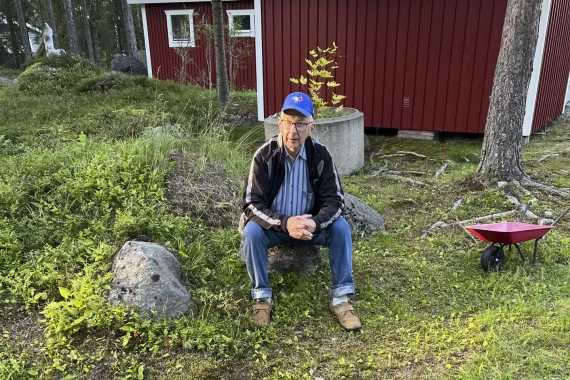 Man sitter på sten på landet