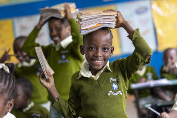Flicka med böcker på huvudet i kenya