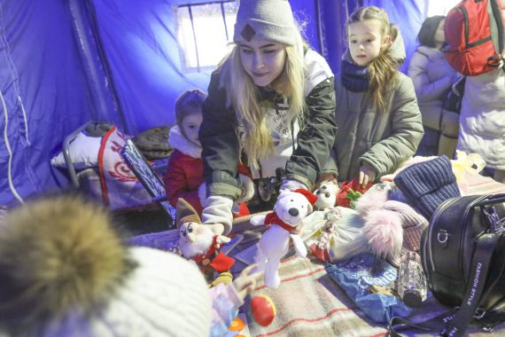 Kvinna tröstar flyktingbarn i Rumänien